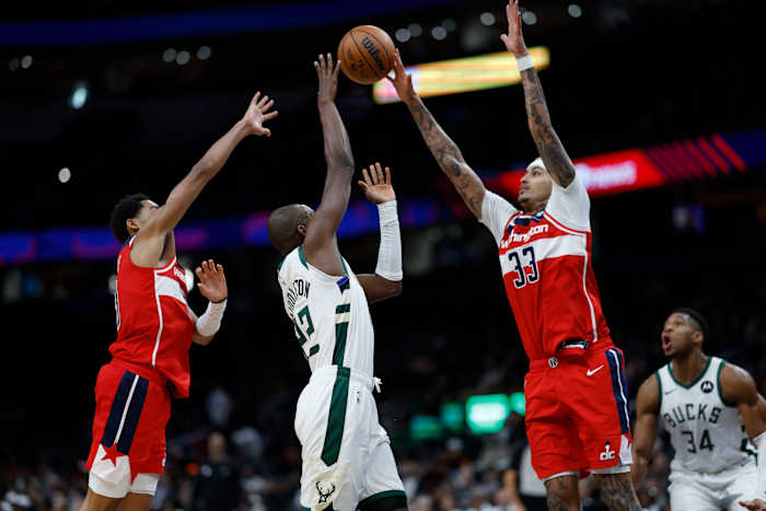 Milwaukee Bucks forward Khris Middleton (22) shoots the ball as Washington Wizards guard Jordan Poole (13) and Wizards forward Kyle Kuzma (33) defend in the fourth quarter at Capital One Arena. Mandatory Credit: Geoff Burke-USA TODAY Sports